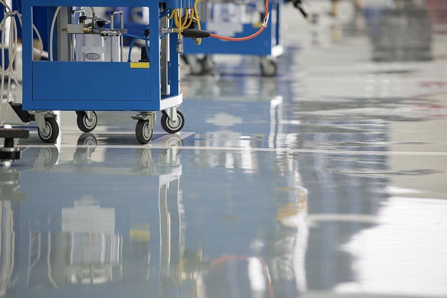 A Blue cart is Sitting on a Shiny Concrete floor in a Factory — Crowfoot Constructions NSW, 2830