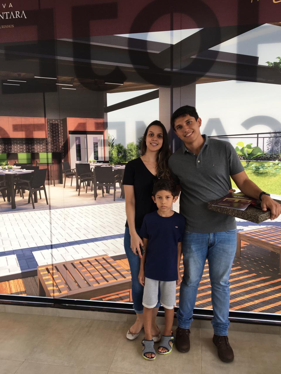 Uma família posando para uma foto em frente a uma placa que diz terra