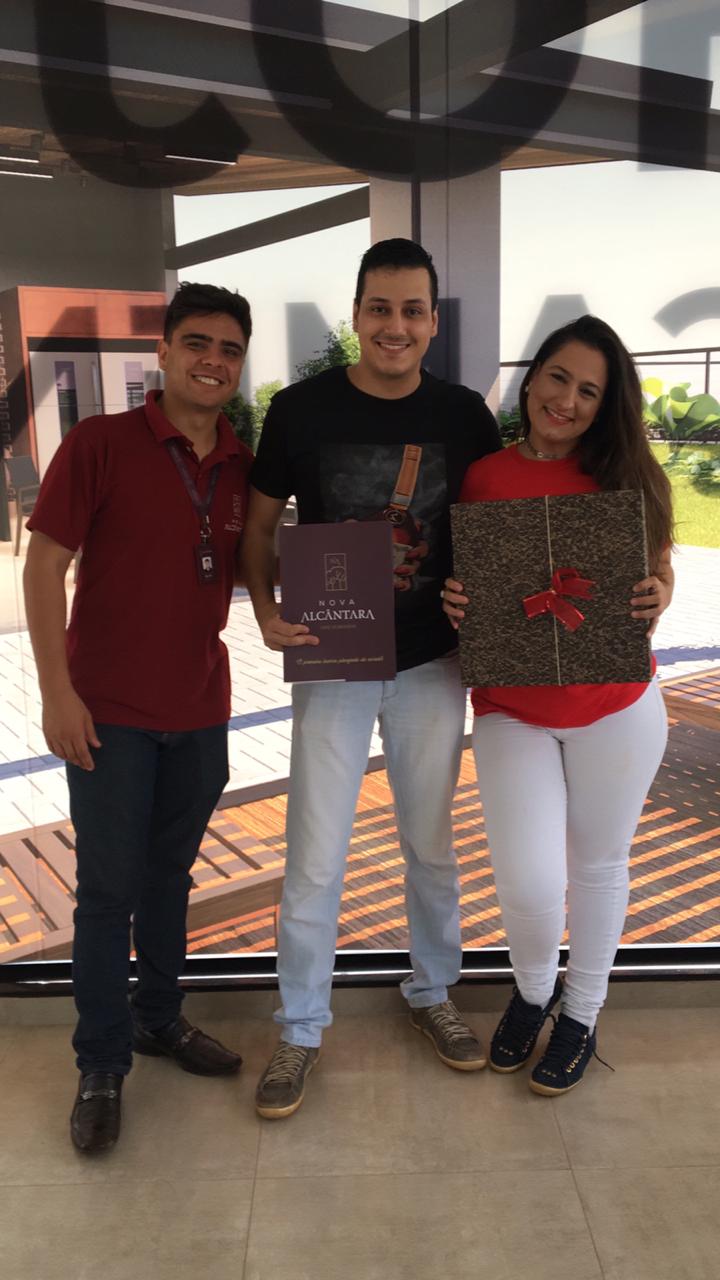 Um grupo de pessoas próximas umas das outras segurando presentes.