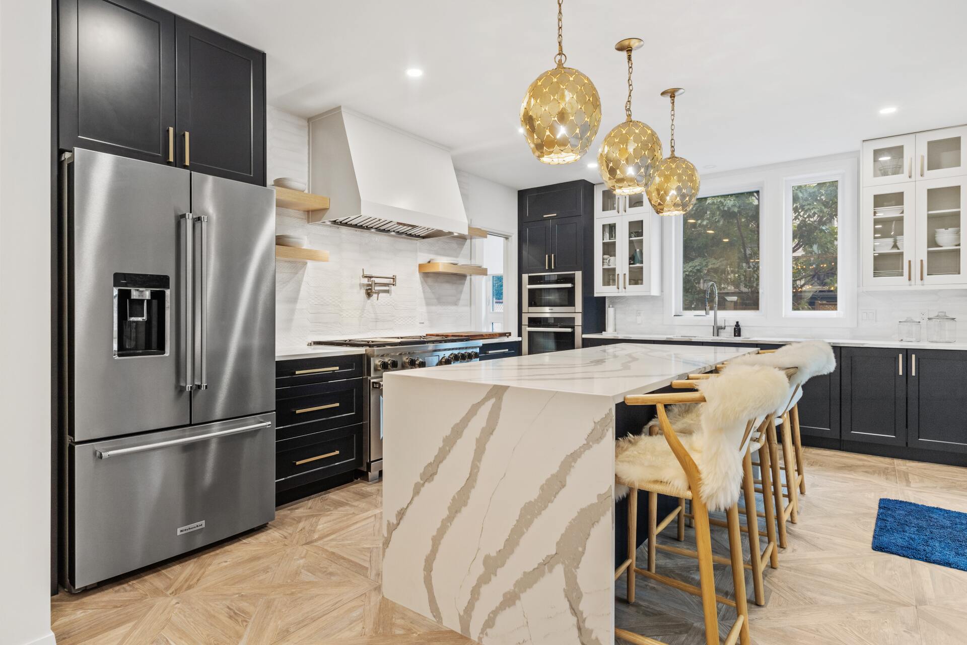 Modern black kitchen cabinets with sleek stainless steel hardware and white countertops.