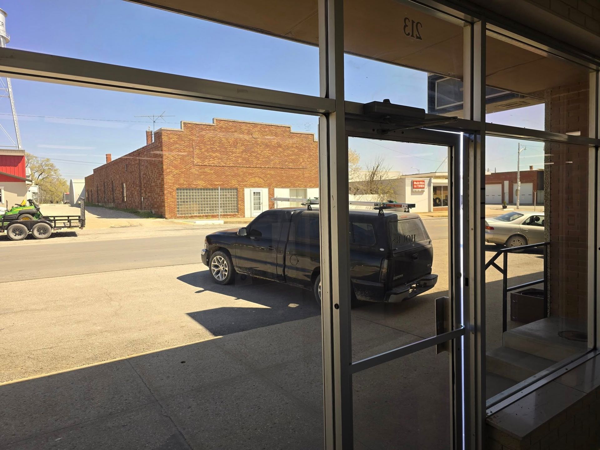 A car is parked on the side of the road in front of a building.
