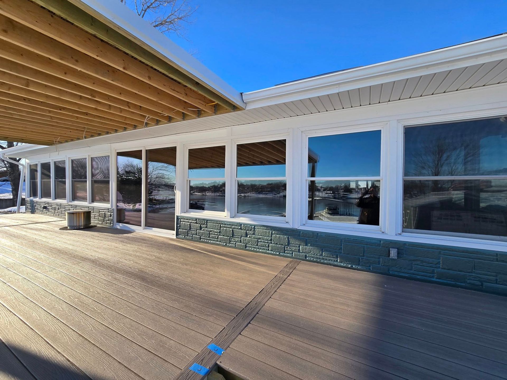 A large white building with a lot of windows and a wooden deck.