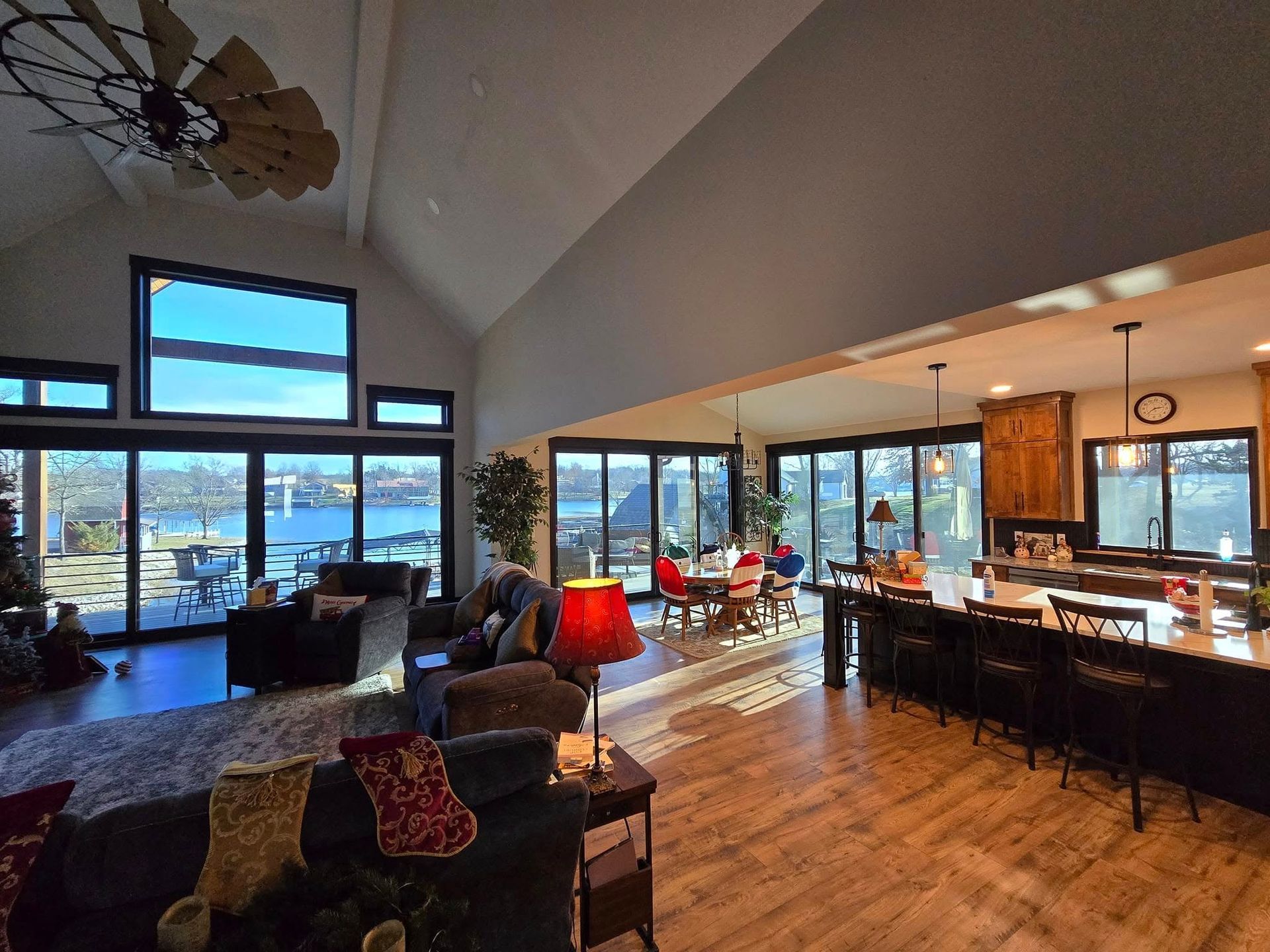 A large living room with a lot of windows and a ceiling fan.