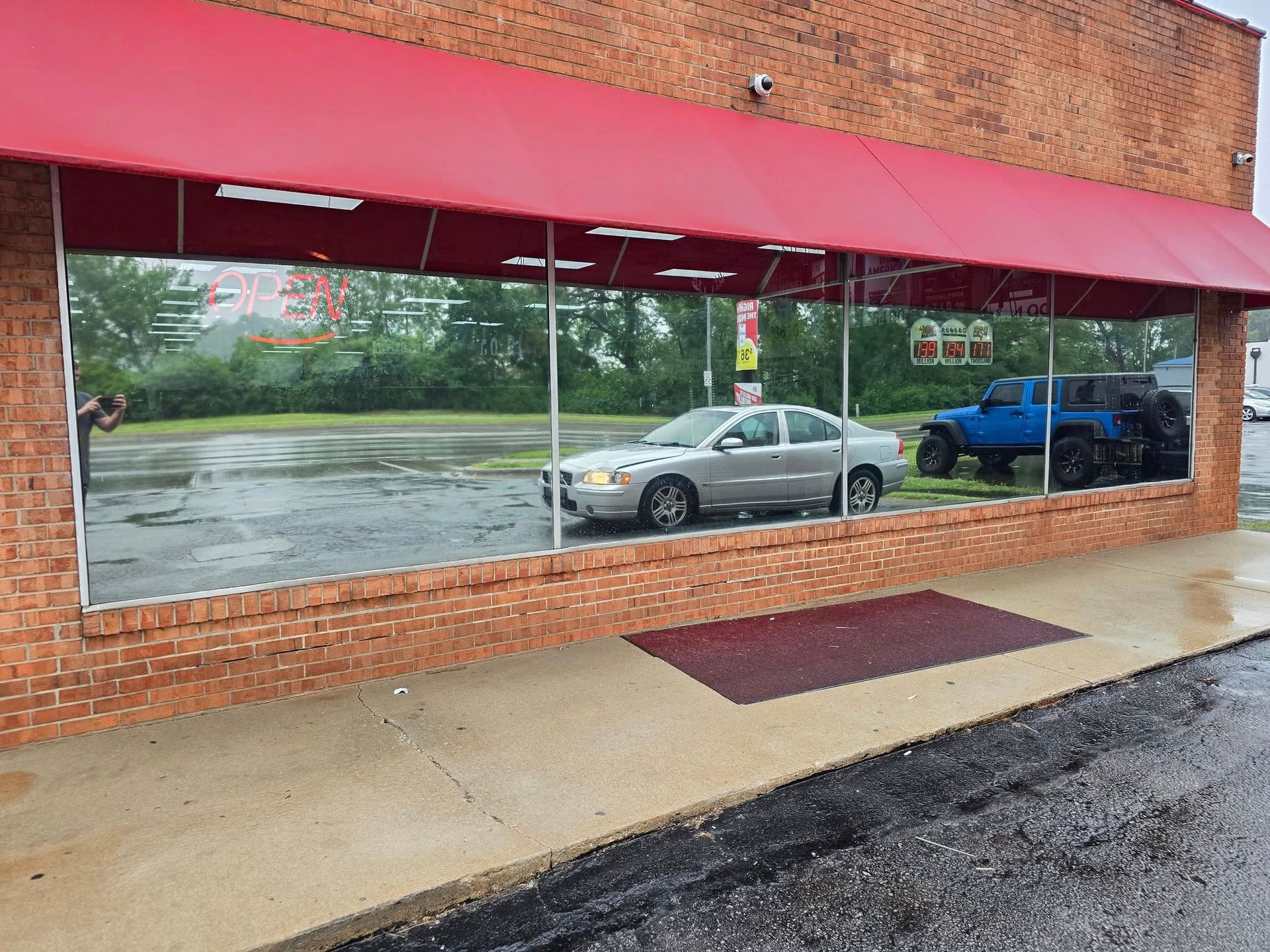 A car is parked in front of a window in a garage.