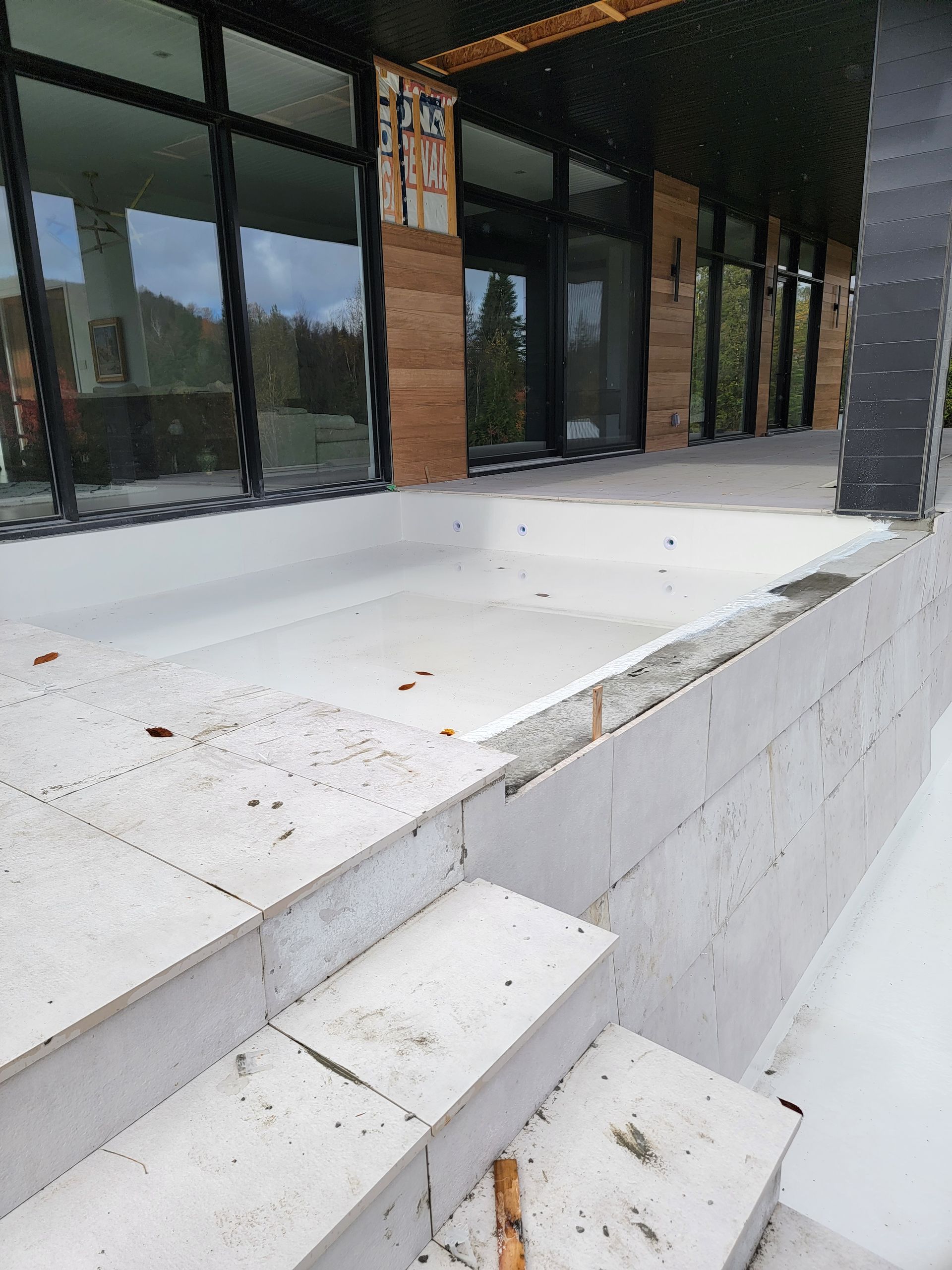 Un escalier menant à une piscine avec un bâtiment en arrière-plan.