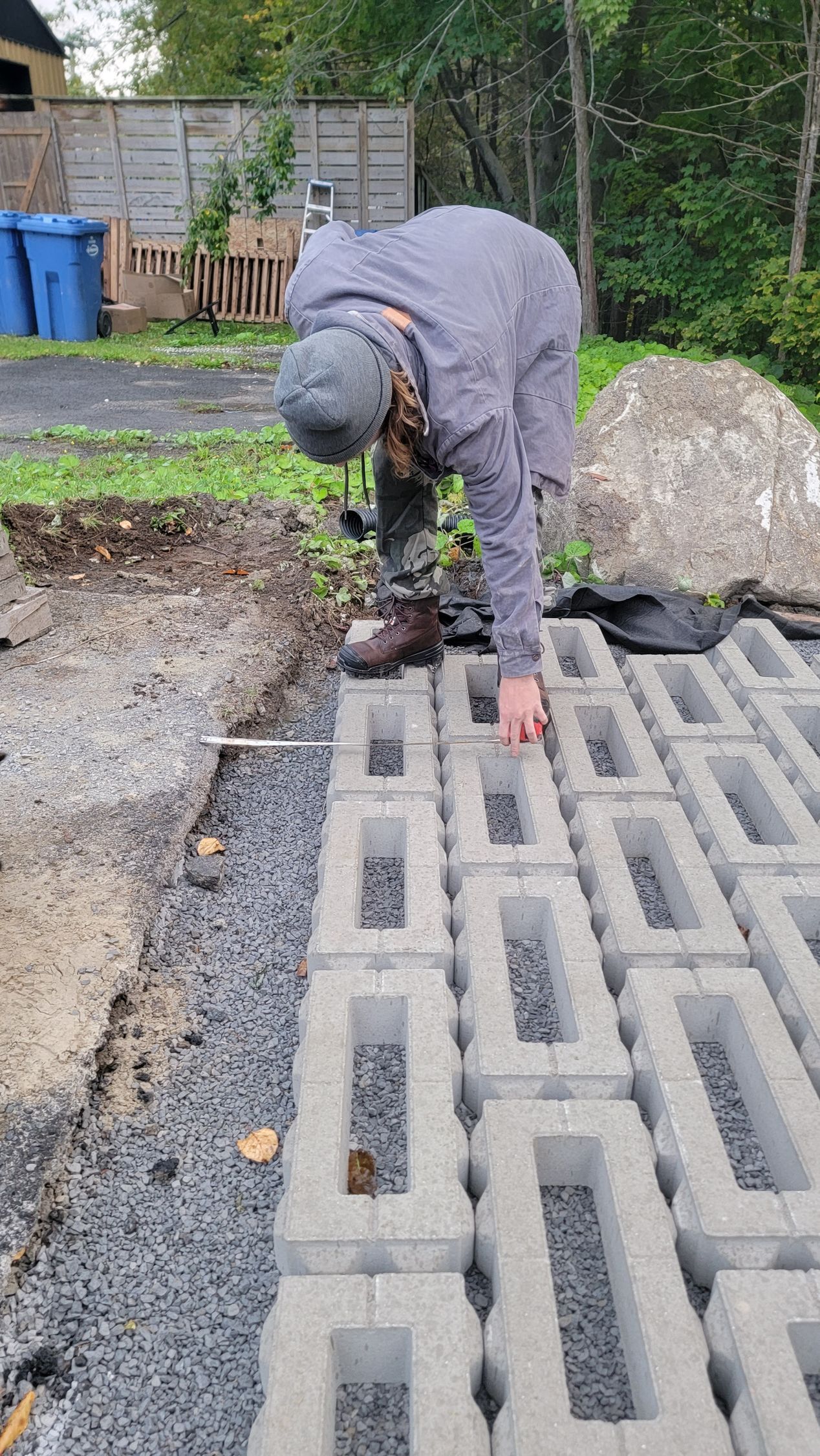 Un homme est penché sur un tas de blocs de béton.