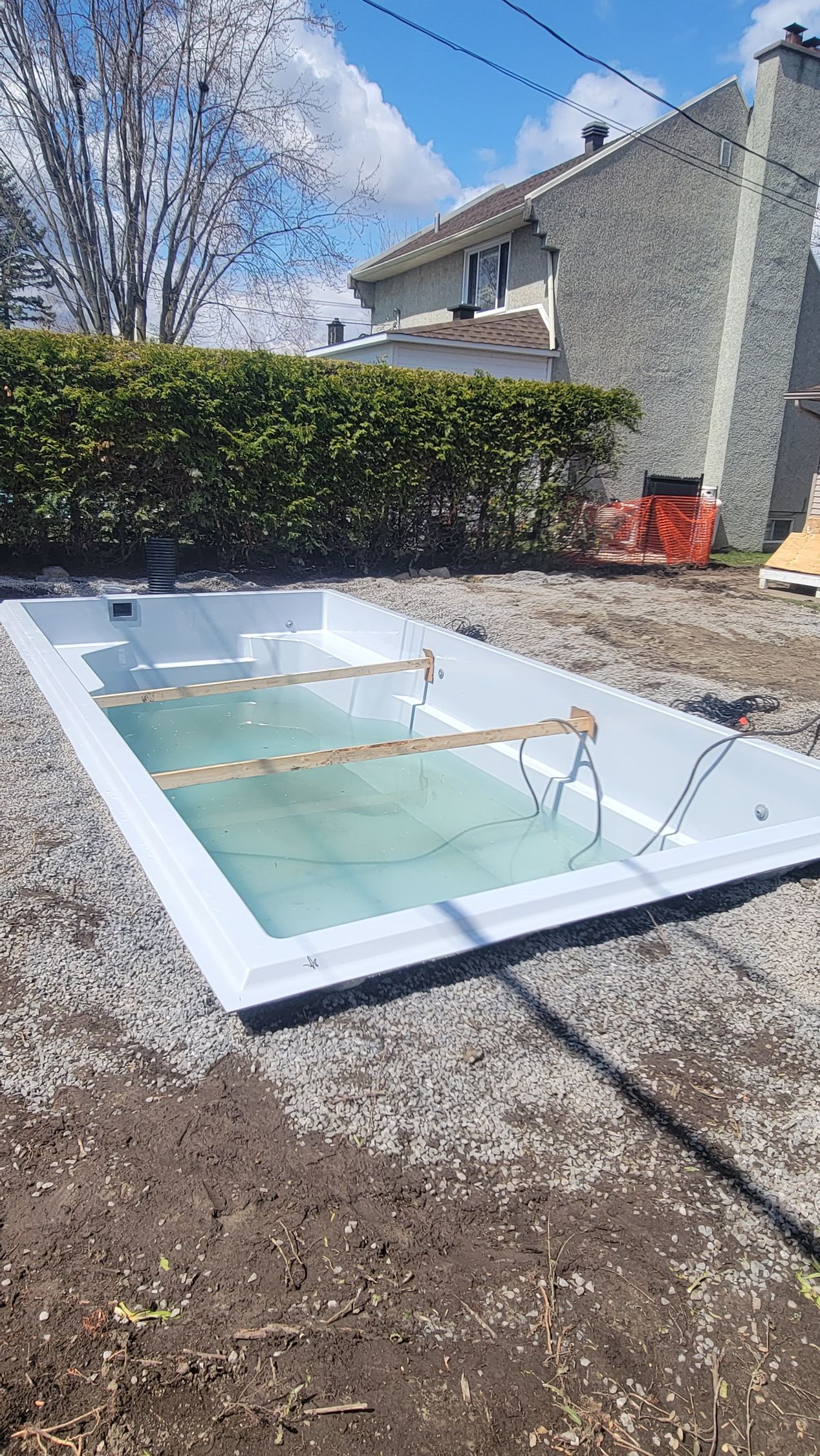 Une piscine est en cours de construction dans l'arrière-cour d'une maison.