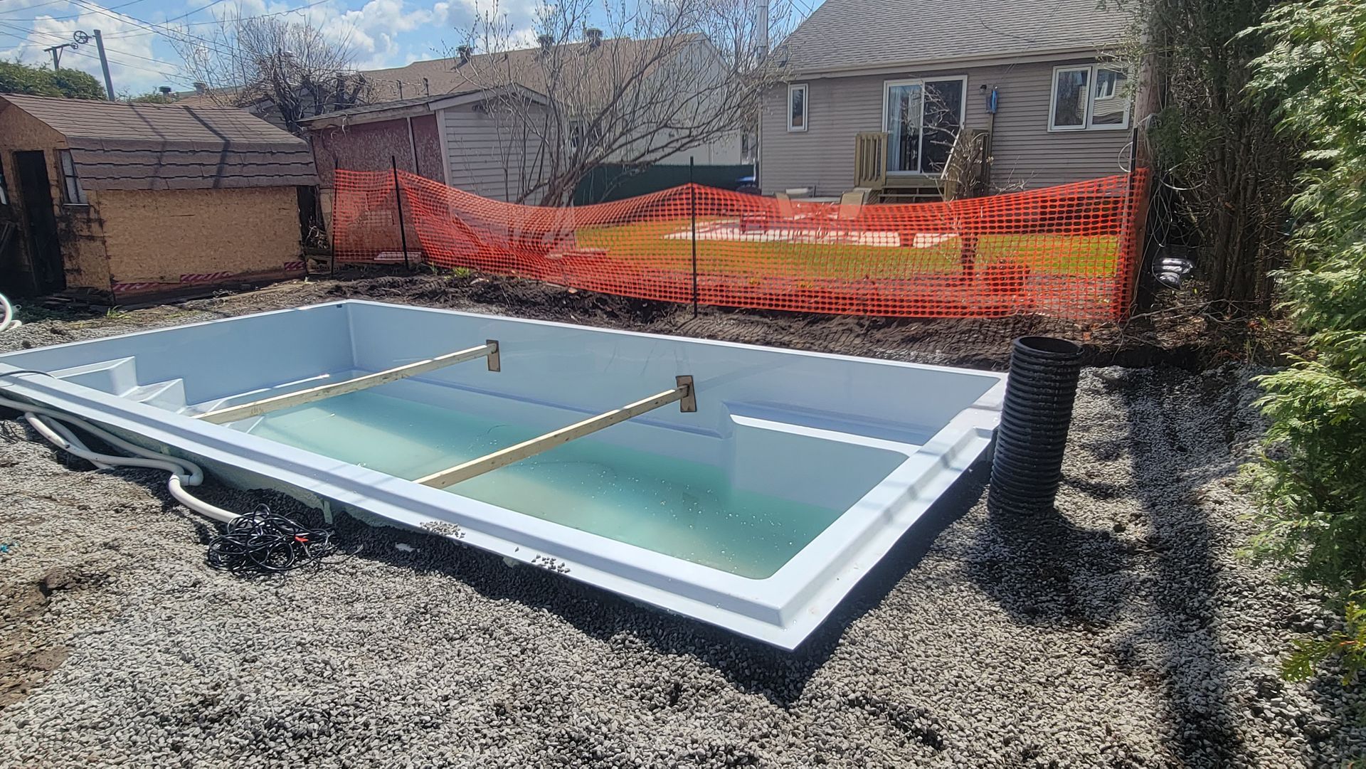 Une piscine est en cours de construction dans l'arrière-cour d'une maison.