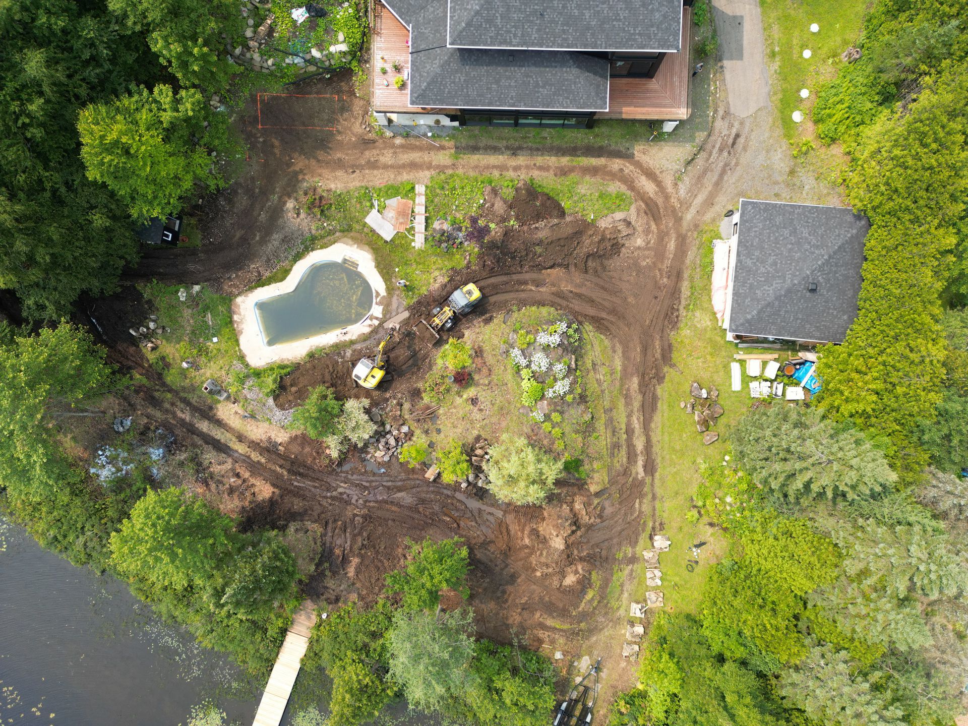 Une vue aérienne d'une maison et d'une piscine entourée d'arbres.