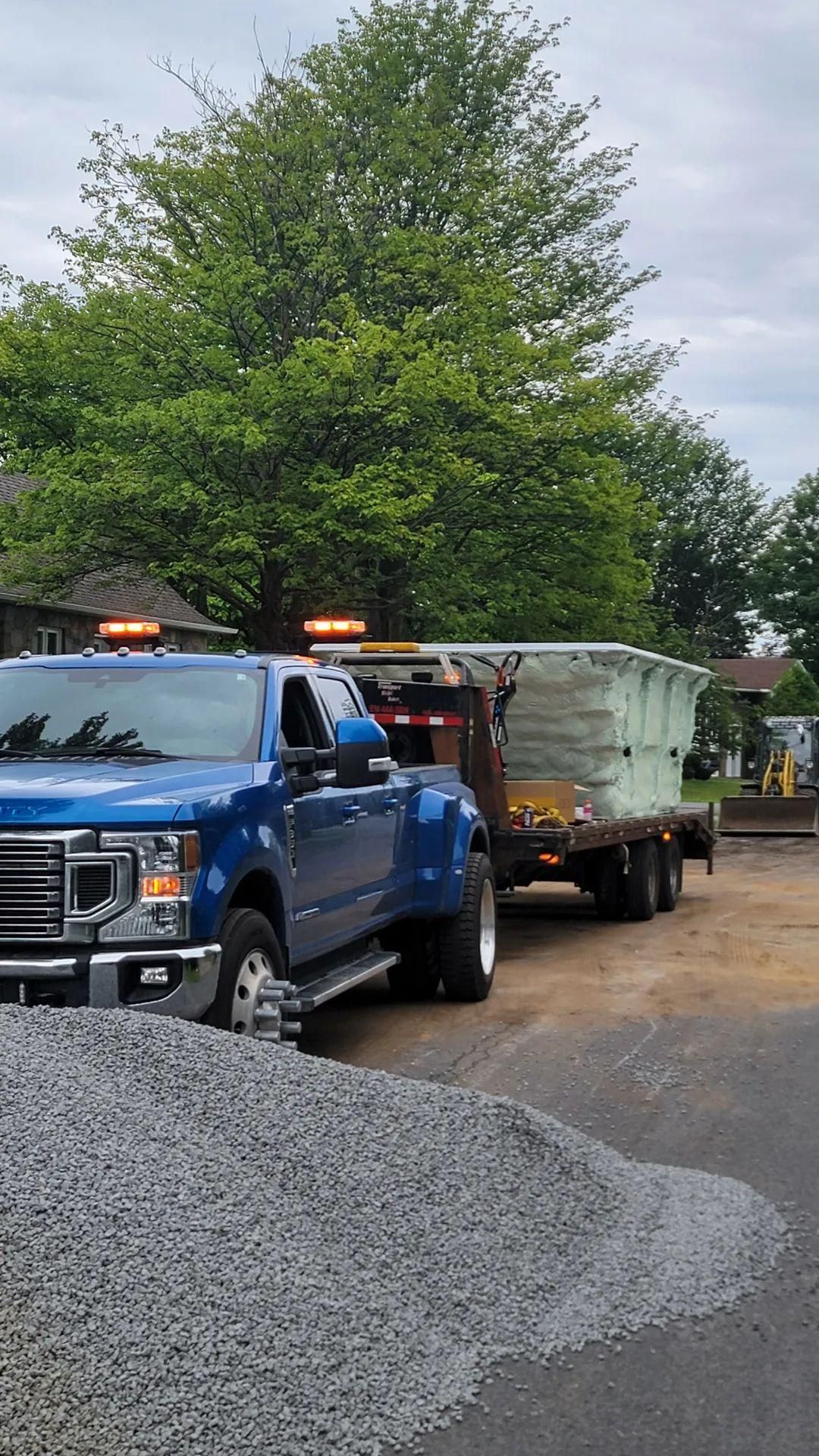 Deux camions bleus sont garés l'un à côté de l'autre sur un chemin de gravier.