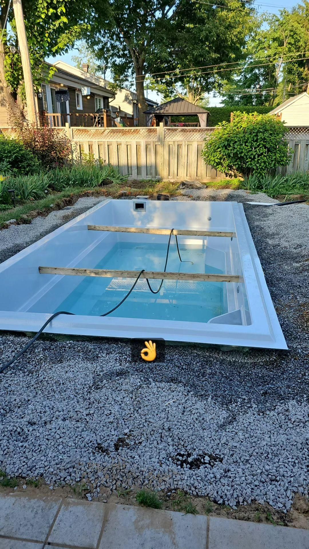Une piscine est en cours de construction dans une cour arrière.