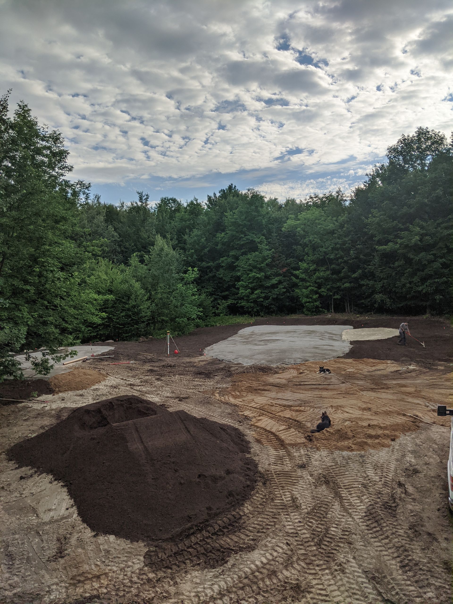 Un tas de terre dans un champ avec des arbres en arrière-plan.