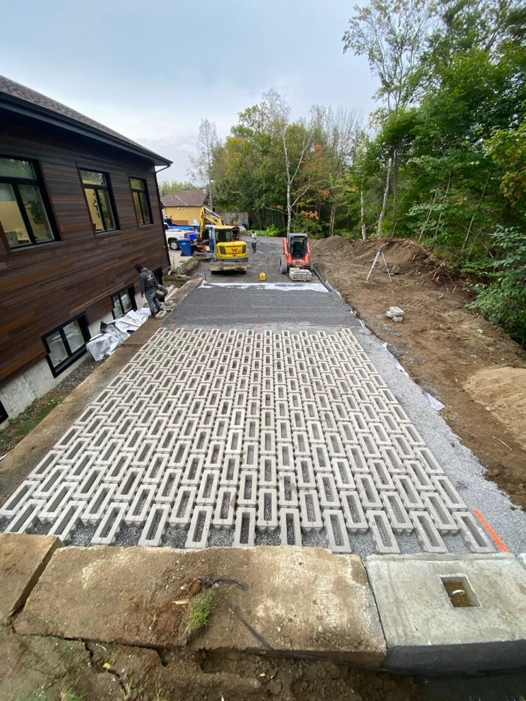 Une allée en béton est en cours de construction devant une maison.