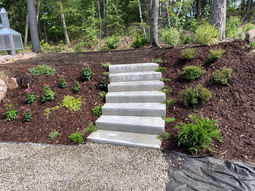 Un ensemble de marches en béton menant à une colline verdoyante.