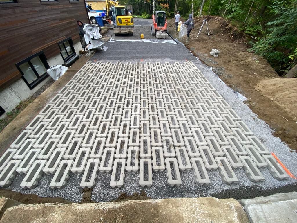 Une allée en béton est en cours de construction devant une maison.