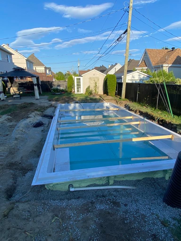 Une piscine est en cours de construction dans l'arrière-cour d'une maison.