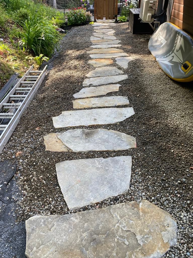 Une allée en pierre menant à une maison avec une échelle en arrière-plan.