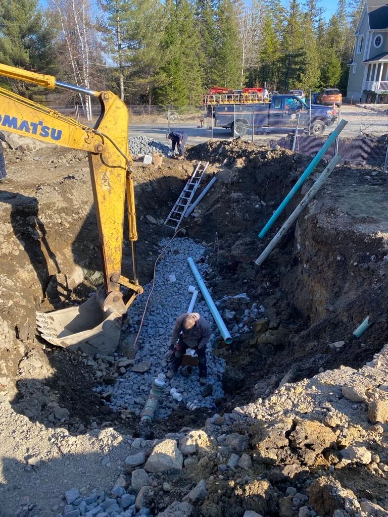 Une excavatrice jaune creuse un trou dans le sol.