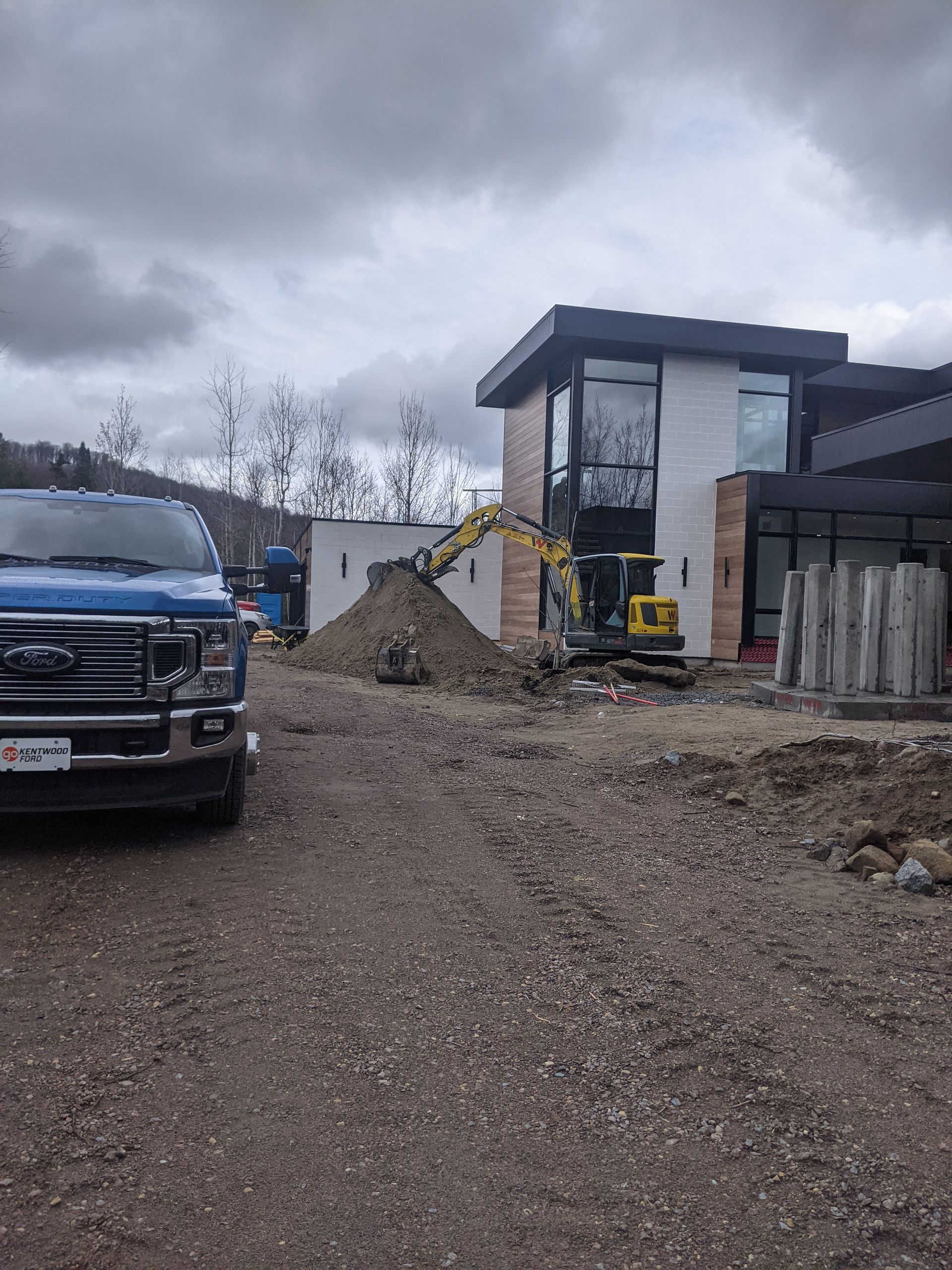 Un camion bleu est garé devant une maison en construction.