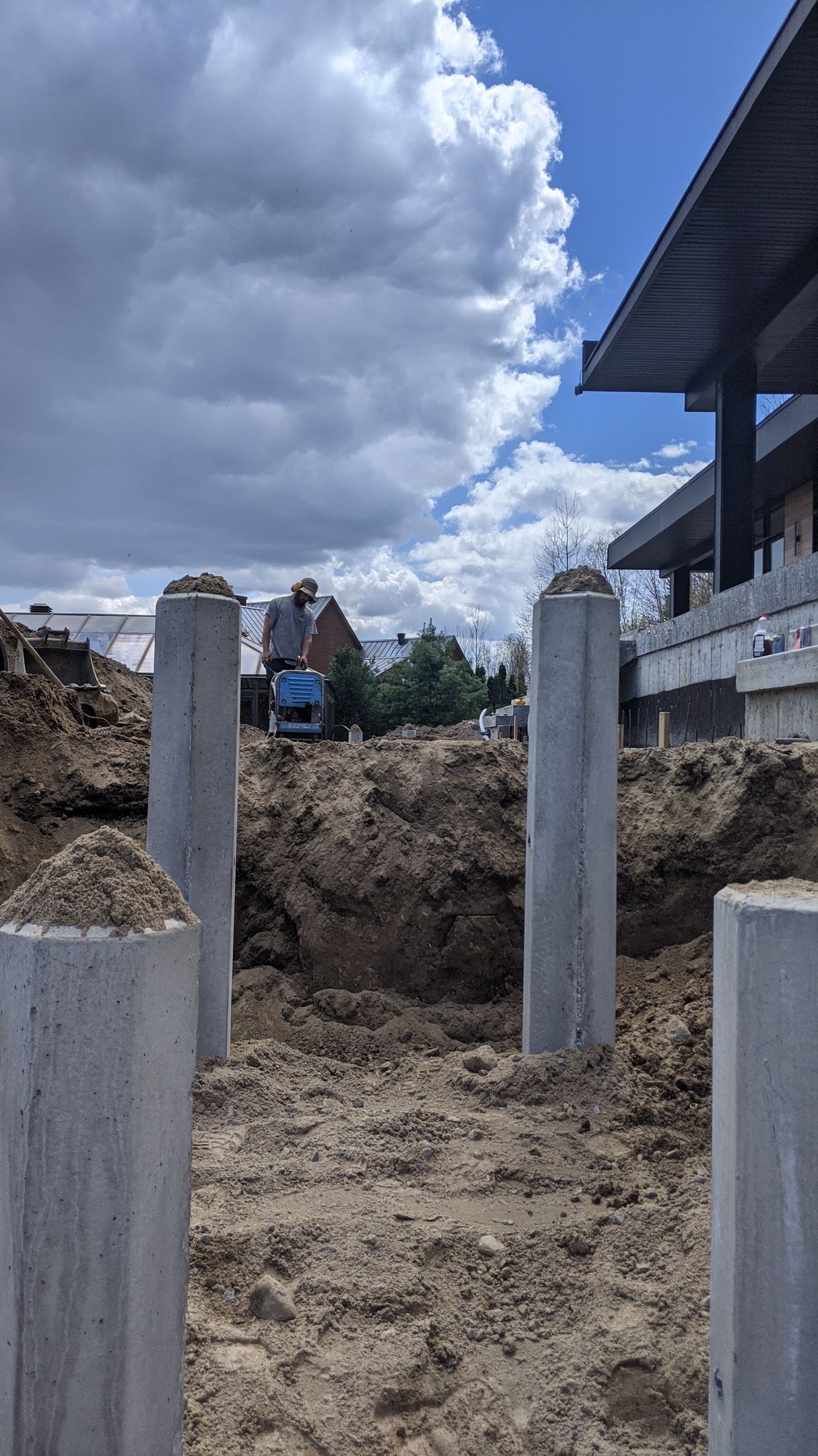 Un homme est assis sur un tas de terre sur un chantier de construction.