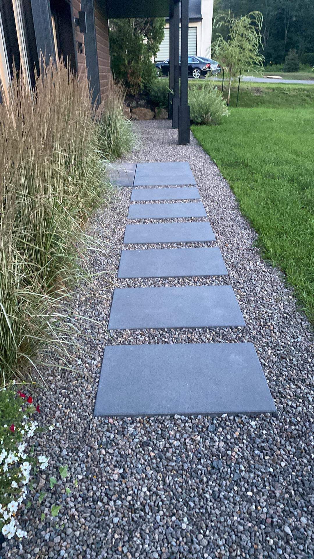 Une allée en pierre menant à une maison dans une cour.