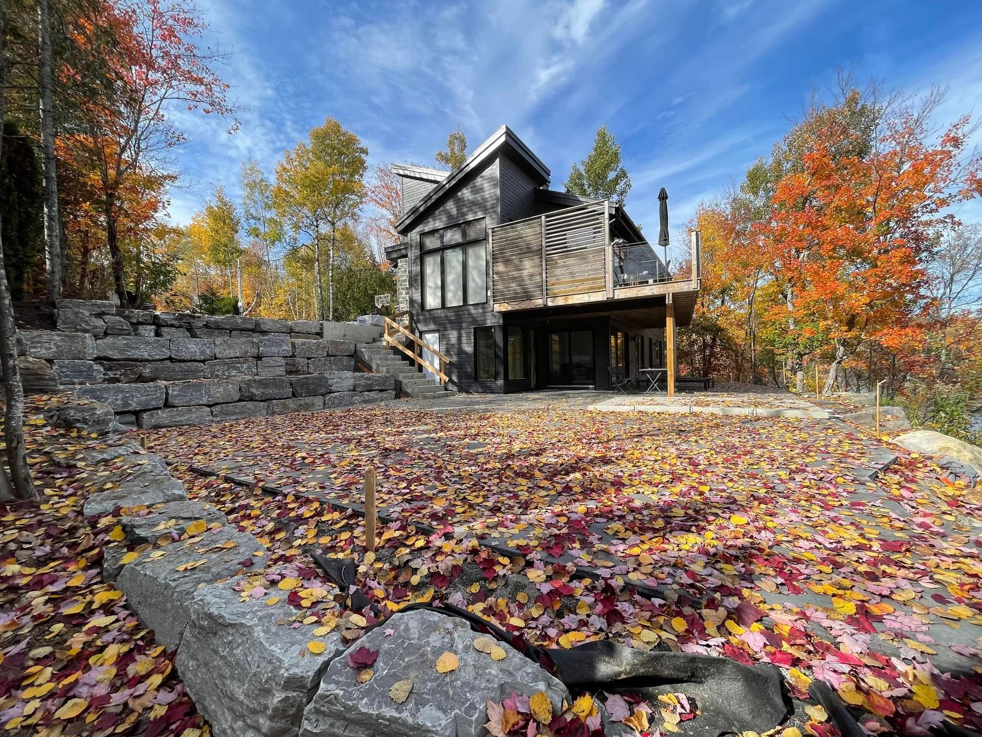 Une maison est entourée d'arbres et de feuilles à l'automne.