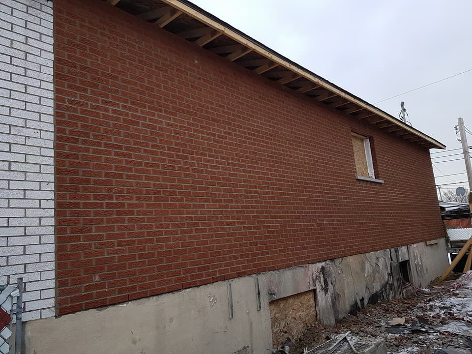 Un bâtiment en briques rouges avec un mur de briques blanches et une fenêtre.