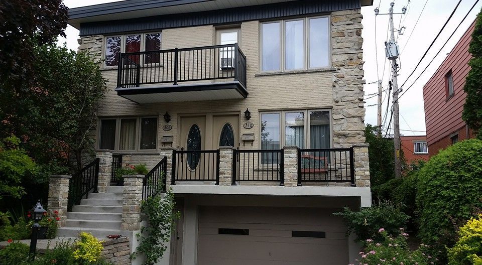 Une grande maison avec un balcon et un garage