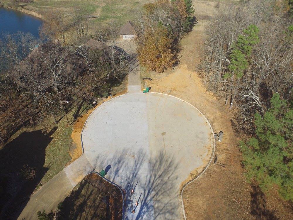 Aerial view of a cul-de-sac and surrounding homes, trees and a body of water.