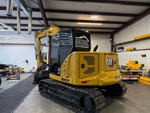 Yellow Caterpillar mini excavator in a workshop.