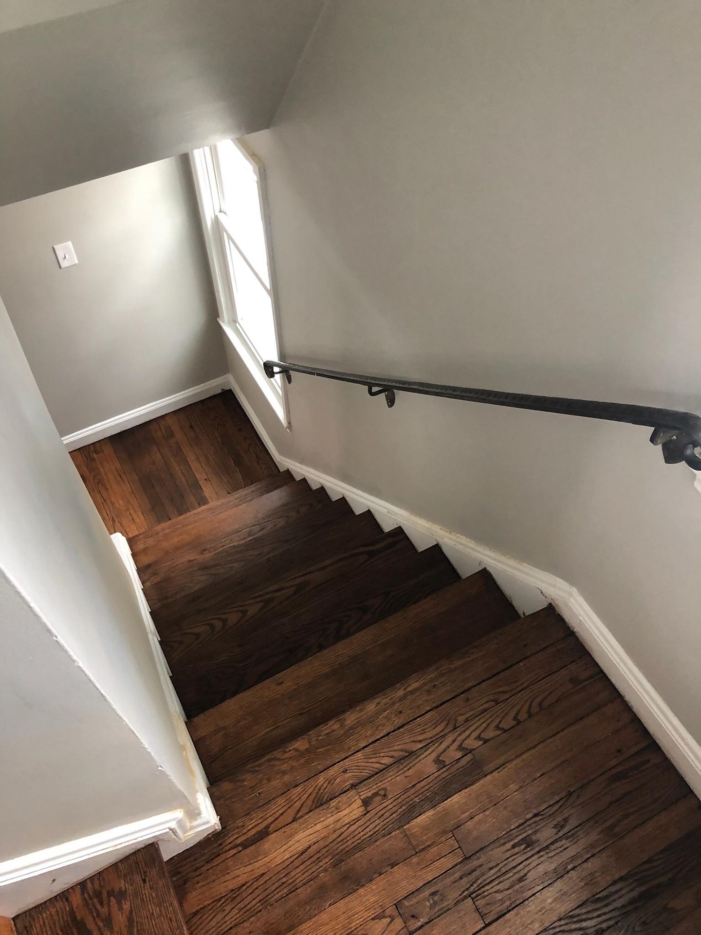 A staircase with wooden floors and a metal railing in a house
