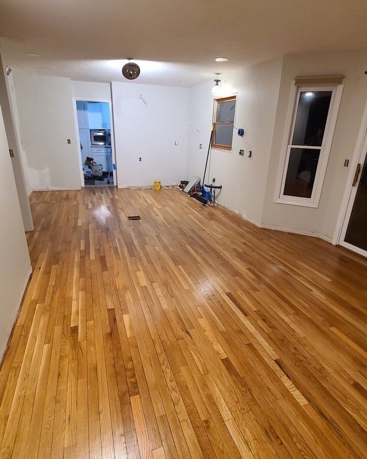 A living room with hardwood floors and white walls