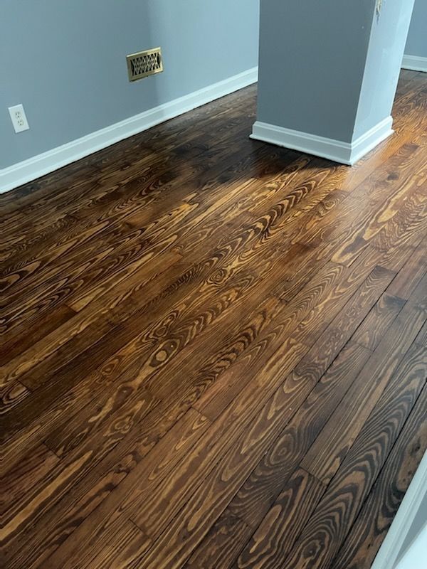 A room with a wooden floor and a gray wall