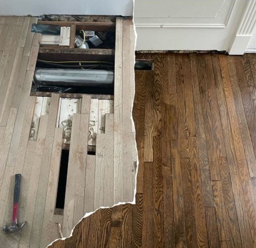 A wooden floor with a hole in it and a hammer next to it