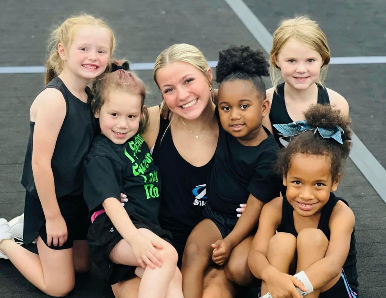 A group of young girls are posing for a picture with their coach