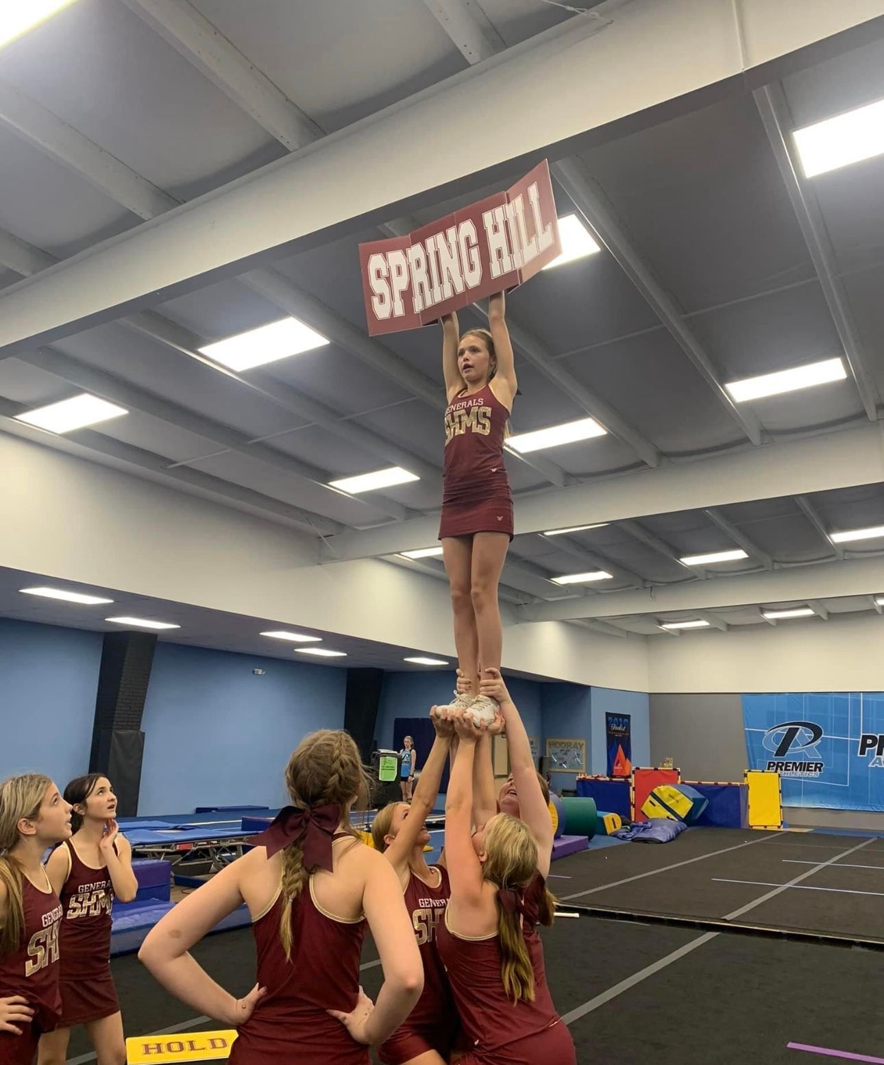 A cheerleader is holding a sign that says spring hill