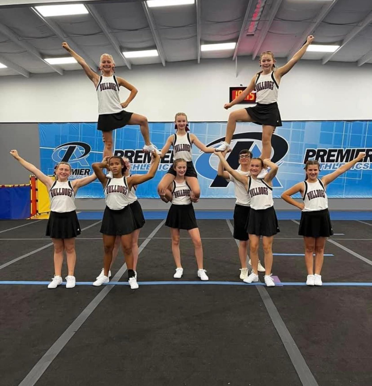 A group of cheerleaders in front of a wall that says premier