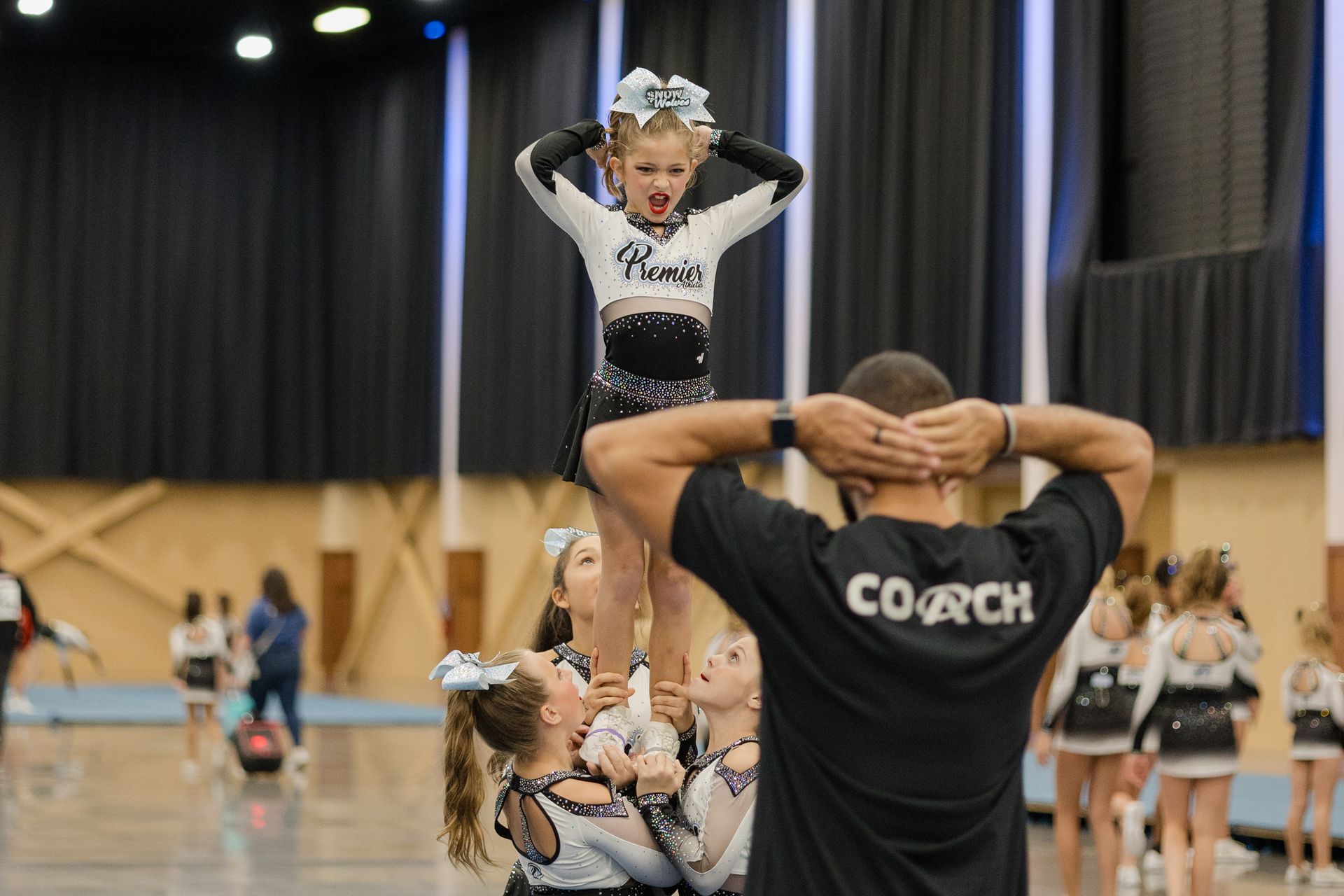 A man is holding a cheerleader up in the air.