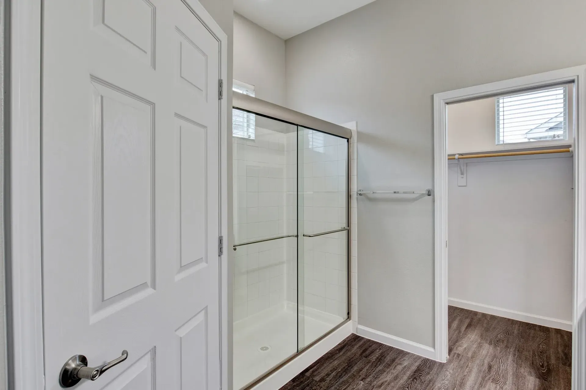 A bathroom with a sliding glass shower door and a walk in closet.