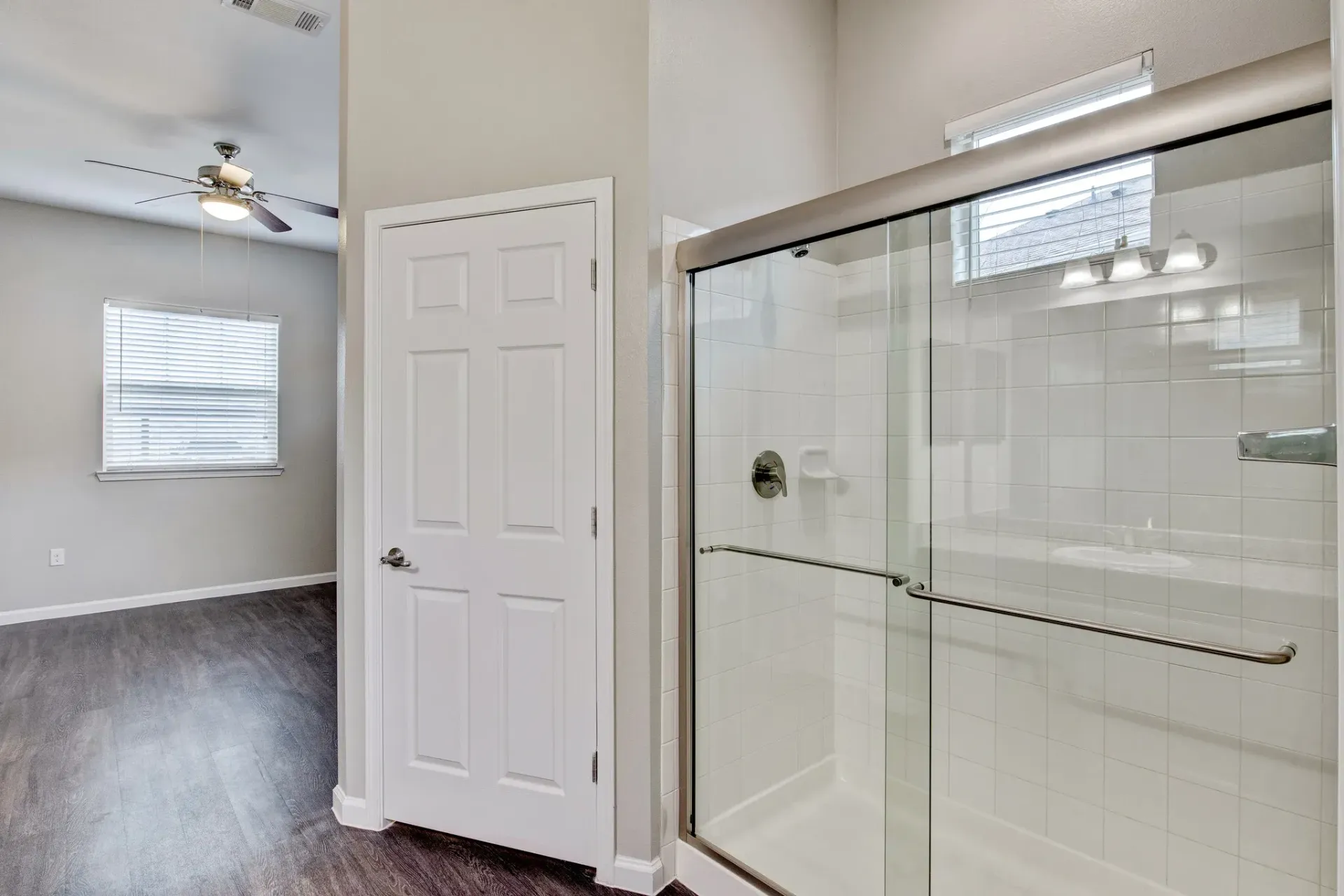 A bathroom with a sliding glass shower door and a bathtub.