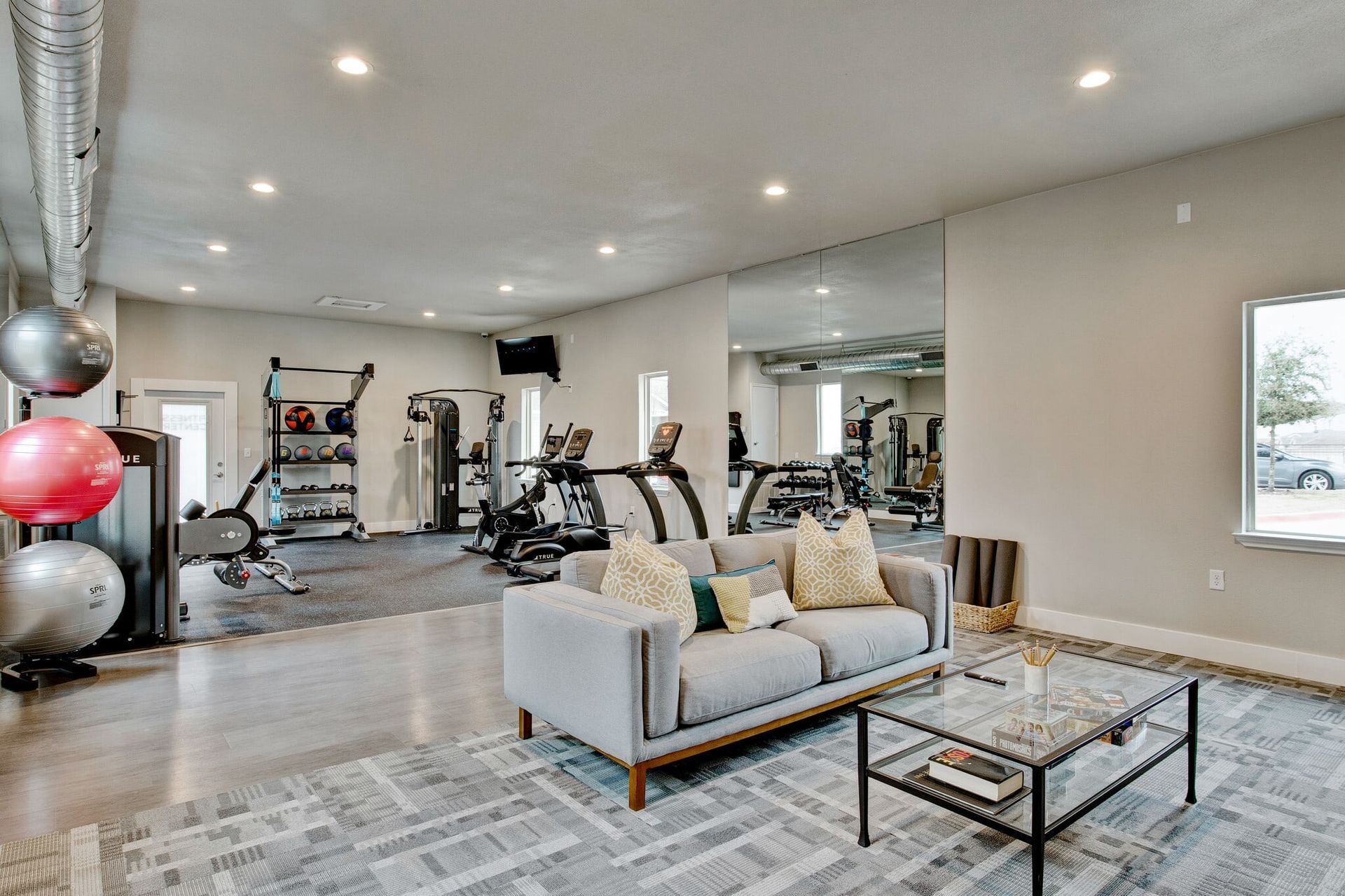 A living room with a couch and a coffee table in a gym.
