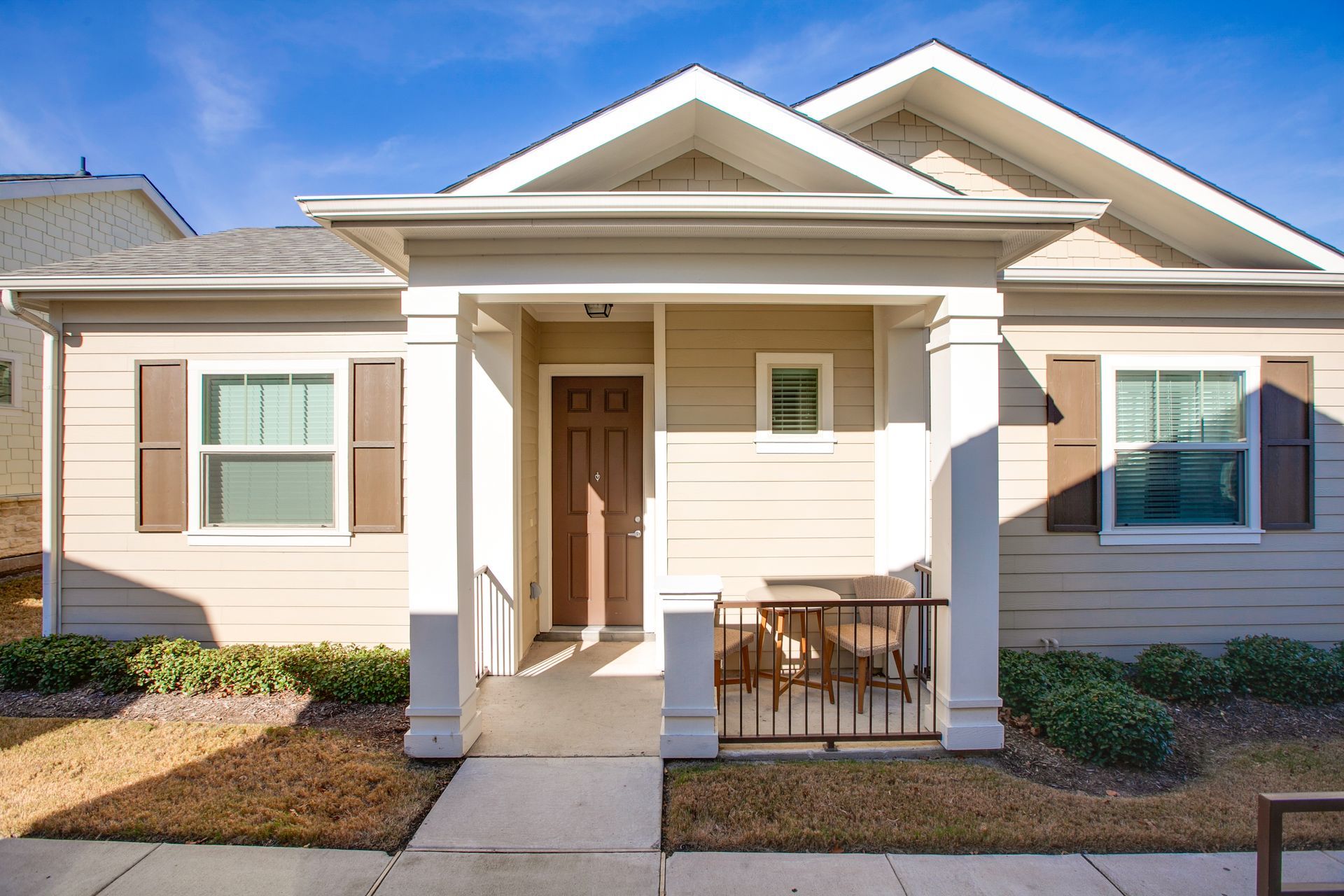 The front of a house with a porch and shutters.