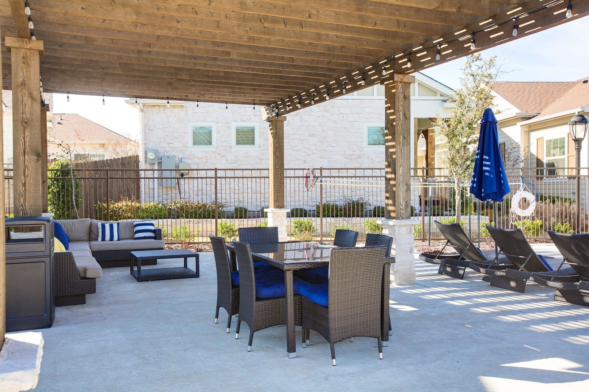 A patio with a table and chairs under a pergola.