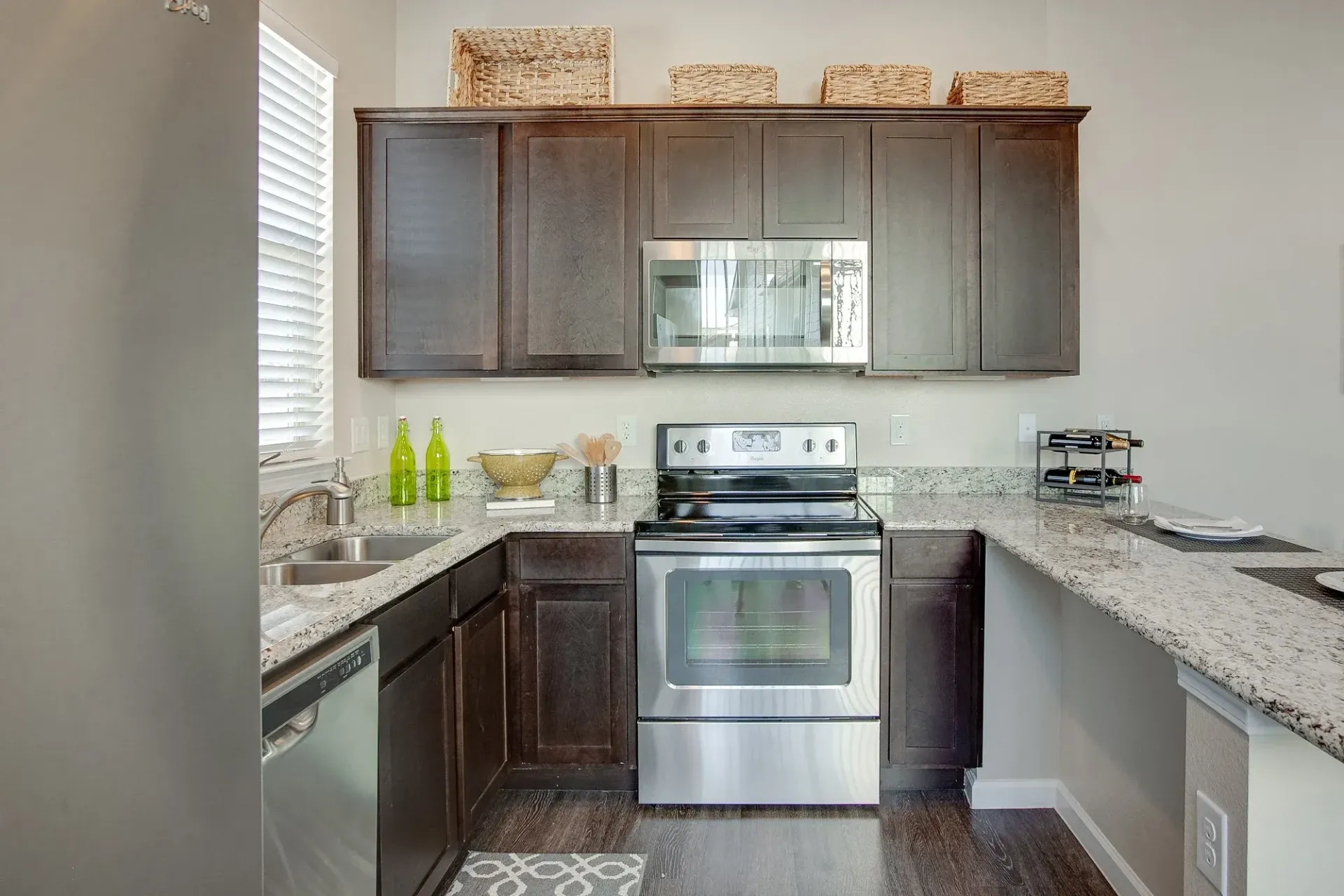 A kitchen with stainless steel appliances and granite counter tops.