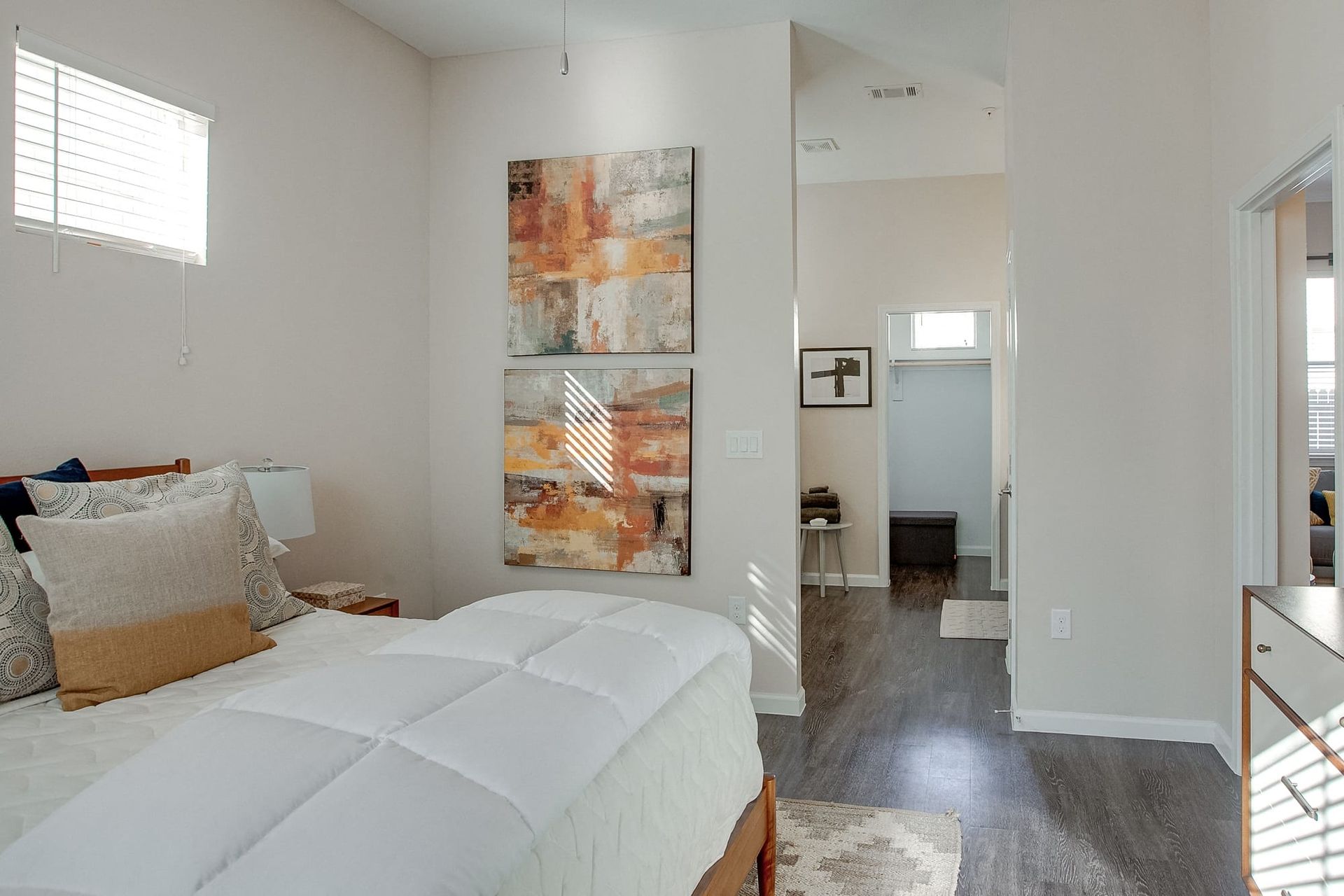 A bedroom with a large bed and a painting on the wall.