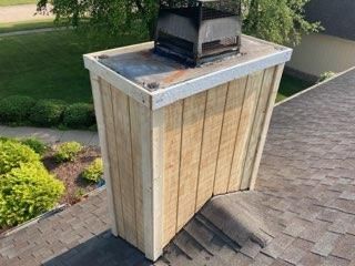 A wooden chimney is sitting on top of a roof.