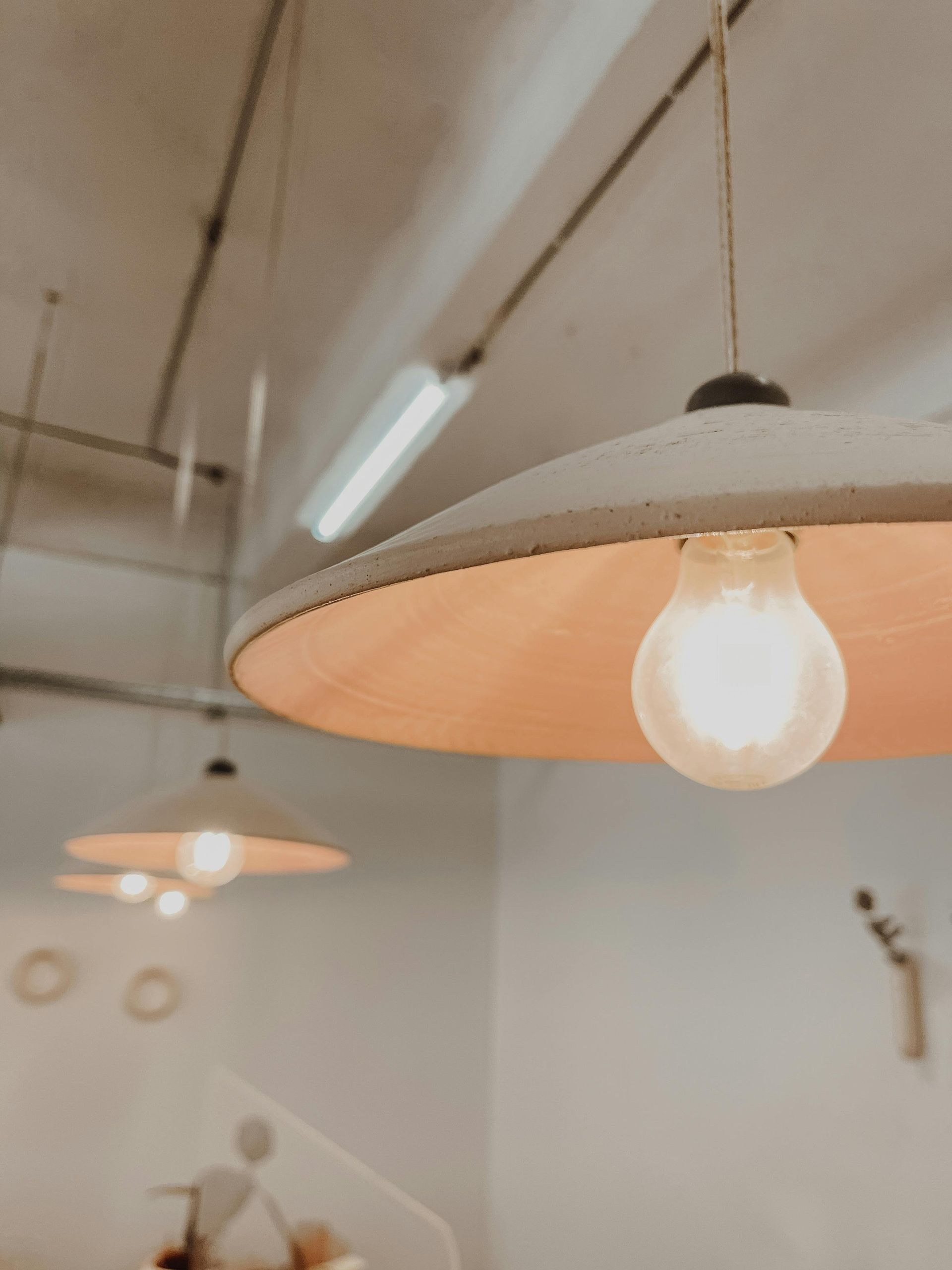 Multiple hanging lamps in a room with a close up of one of them.