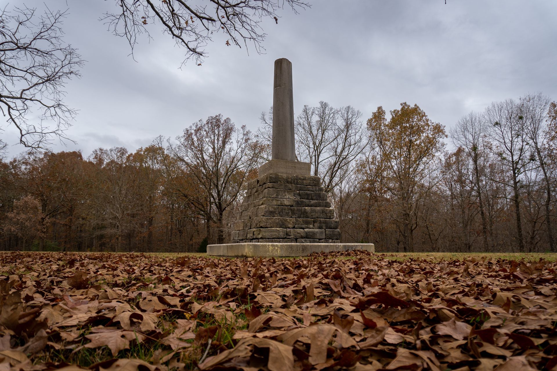 There is a monument in the middle of a field of leaves.
