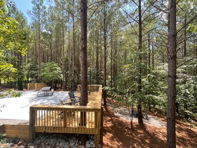 A wooden deck in the middle of a forest surrounded by trees.