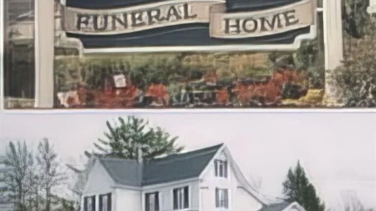 Funeral home sign above a white Victorian house with a dark roof.